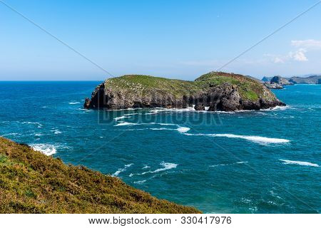 Scenic View Of Sea Against Blue Sky In Rocky Coast