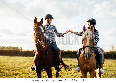 Happy Loving Couple Spending Time With Horses On Ranch