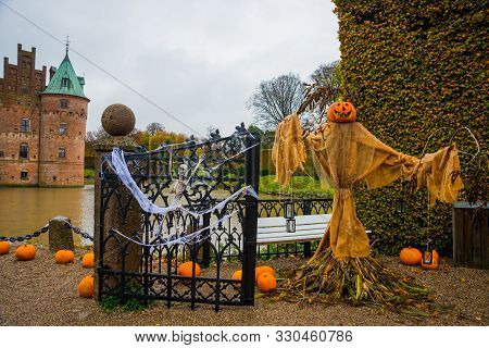 Egeskov Slot, Denmark, Halloween: Scarecrows And Pumpkins Decorate The Entrance To The Bridge To The
