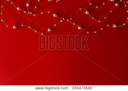 Gold Wedding Rings Close Up On A Beige Backgroundchristmas Background. Gold Beads And Yellow Garland