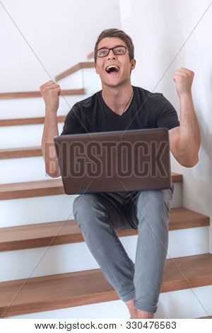 happy young man looking at his laptop screen