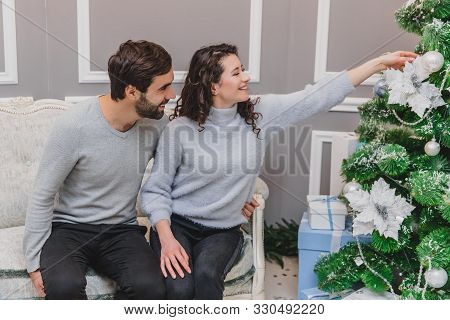Cheerful Women And Men Having Fun While Lights Are Sparkling On The Christmas Tree.