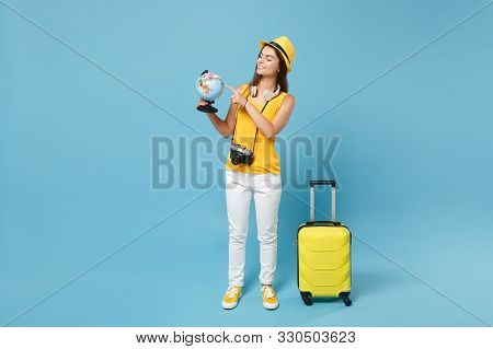 Traveler Tourist Woman In Yellow Casual Clothes, Hat With Suitcase Photo Camera Isolated On Blue Bac