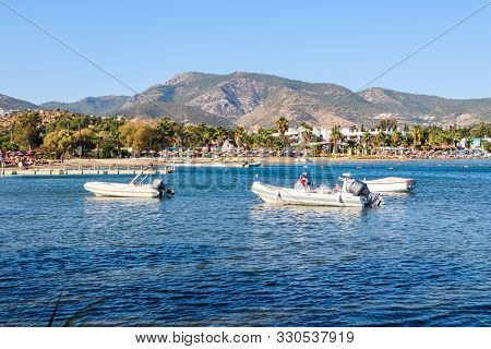 Beautiful Bay With Blue Water, Sandy Beach And Boats. Small Town And Green Mountains On The Coast Of