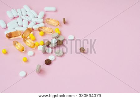 Assorted Pharmaceutical Medicine Pills, Tablets And Capsules On Pink Background. Top View. Flat Lay.