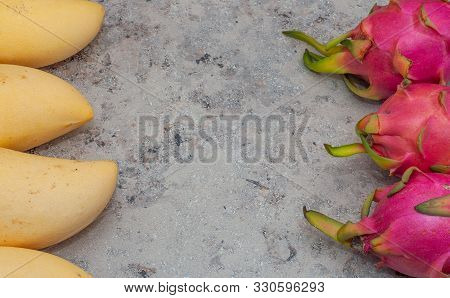 Yellow Mango And Pitahaya On A Gray Background. Horizontal Orientation.