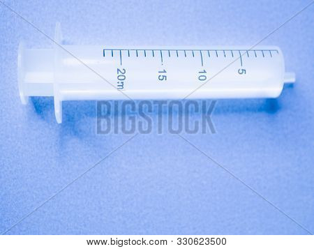 White Syringe On A Blue Background. Syringe On Blue Background. 5ml Syringe On Blue Background. Medi