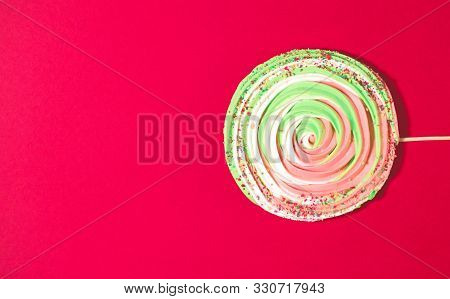 Big Colorful Spiral Meringue On Stick On Red Background. Festive And Party Concept. Minimal Style. F