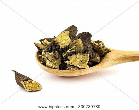 Dried Licorice Or Liquorice Roots Lie In A Wooden Spoon On A White Background.