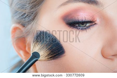Makeup Artist Applying Makeup On Her Face Using Powder Brush