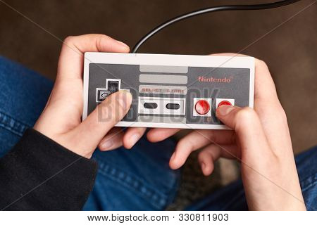 BUDAPEST, HUNGARY - FEBRUARY 17, 2018: Playing the classic Nintendo NES console from the 80s, controller closeup