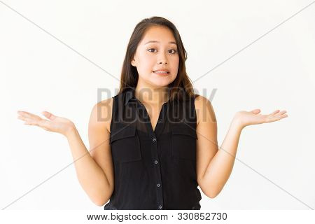 Doubtful Woman Gesturing With Hands. Portrait Of Beautiful Young Uncertain Woman Gesturing With Hand