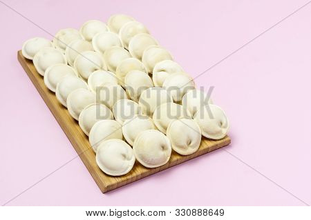 Tasty Homemade Frozen Pelmeni On Wooden Board On Pink Background Russian Dish Background With Frozen