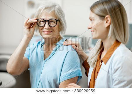 Happy Senior Woman Patient Checking Vision With New Eyeglasses During A Medical Consultation With Op