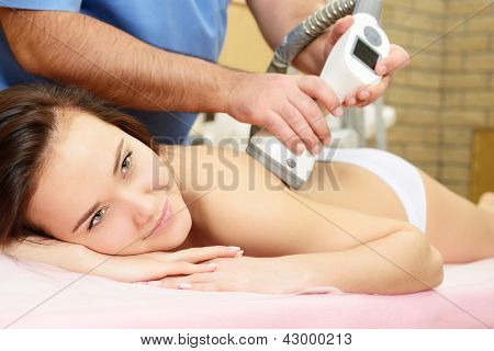 jovem bela mulher recebendo terapia de massagem nas costas, no salão de beleza