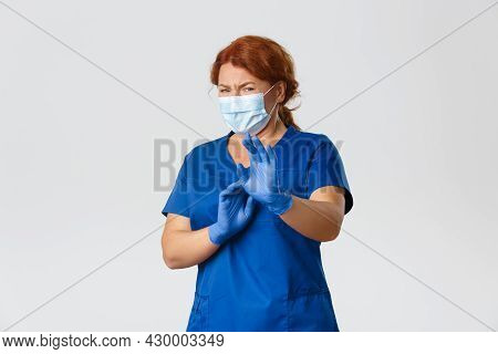 Medical Workers, Covid-19 Pandemic, Coronavirus Concept. Disgusted And Reluctant Female Doctor In Fa