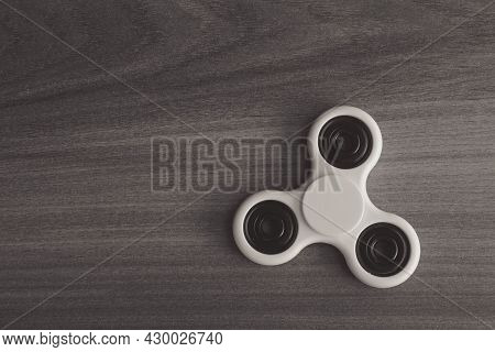 Colourful Fidget Finger Spinner Stress, Anxiety Relief Toy On Wooden Background. Selective Focus.