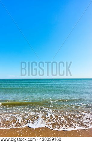 Sea and beach. Seascape with clear horizon and serene blue sky, vertical wallpaper for mobile devices