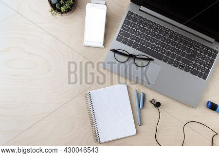 Working Business Space. Laptop, Notepad, Telephone, Microphone On A Wooden Background With Copy Spac