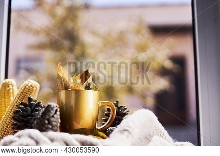 Corns, Autumn Leaves, Pine Cones And Coffee Cup On Windowsill. Creative Autumnal Background Near The