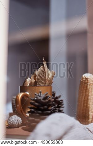 Corns, Autumn Leaves, Pine Cones And Coffee Cup On Windowsill. Creative Autumnal Background Near The