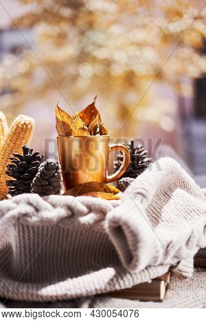 Corns, Autumn Leaves, Pine Cones And Coffee Cup On Windowsill. Creative Autumnal Background Near The