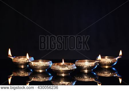 Many Lit Diyas On Black Background, Space For Text. Diwali Lamps