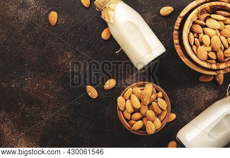 Plant Based Almod Milk In Bottles On Brown Background. Copy Space. Top View