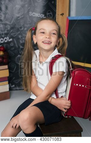 Happy Schoolchild In The Classroom With Big Backpack And Positive Emotions. Excieted And Ready To St