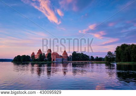 Trakai Island Castle in lake Galve, Lithuania on sunset with dramatic sky reflecting in water. Trakai Castle is one of major tourist attractions of Lituania