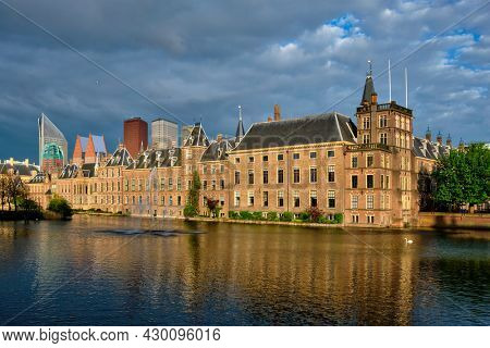 View of the Binnenhof House of Parliament and the Hofvijver lake with downtown skyscrapers in background. The Hague, Netherlands