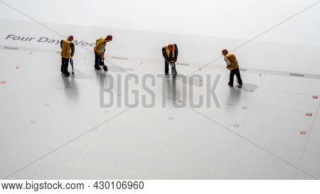 Printed Calendar For A 4 Day Working Week Showing Weekend Days In Red With Small Workmen Working In 