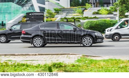 Black Volkswagen Passat B7 Car Seventh Generation Speed Driving On Asphalt City Road At Daytime. Mos