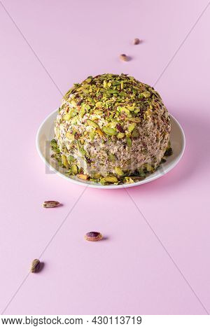 Ready To Eat Sesame Halva With Pistachios On White Plate And Few Scattered Nuts On Pink Paper Backgr
