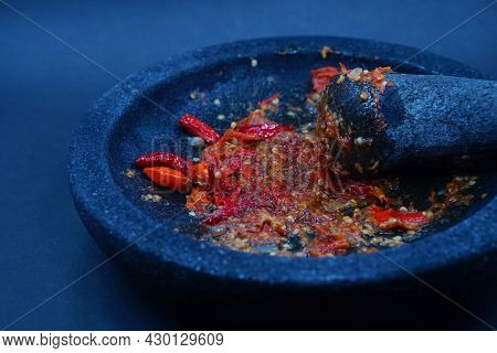 Red Chili Sauce On A Stone Mortar And Pestle. Dark Background, Focus Selected.
