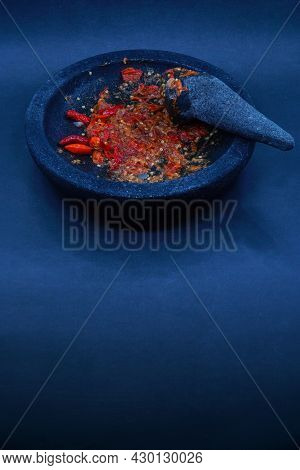 Red Chili Sauce On A Stone Mortar And Pestle. Dark Background, Focus Selected.