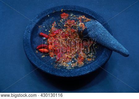 Red Chili Sauce On A Stone Mortar And Pestle. Dark Background, Focus Selected.