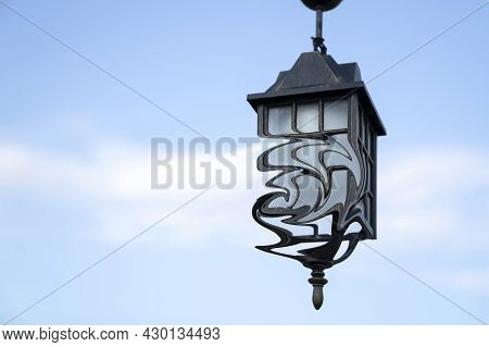 Ancient Street Lamp With Distorted Form On Background Blue Sky, Close Up. Copy Space.