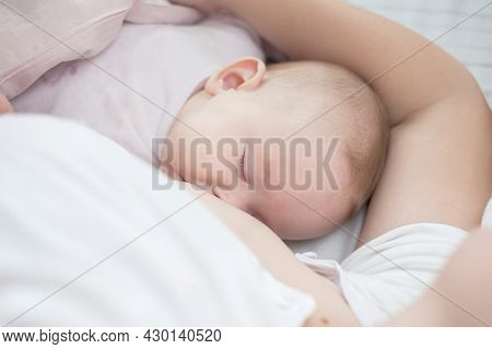 Mother Holding Newborn Baby In An Embrace And Breastfeeding. Mother Is Breastfeeding Her Baby. Newbo