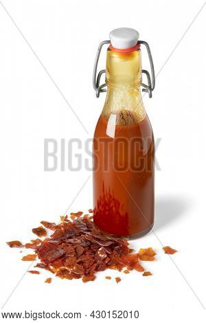 Bottle of brown Shellac liquid and a heap of shellac flakes isolated on white background