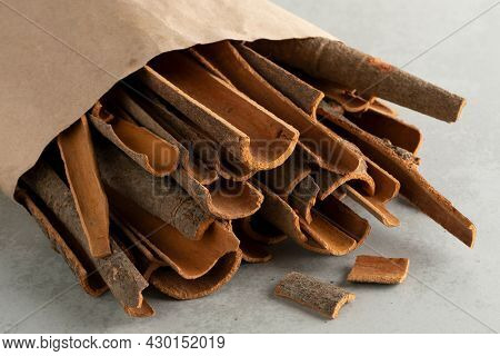 Paper bag with dried cassia cinnamon bark pieces close up  