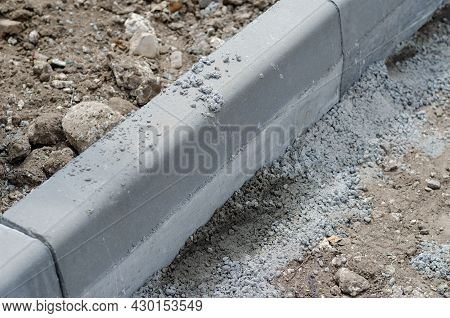 Installation Of New Curbs. The Gray Curbs Are Fixed In Cement Mortar. Construction Of A New Road Or 