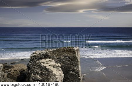 View Of Playa De Las Catedrales In Ribadeo, Galicia, With The Sea In The Background And Cloudy Sky.