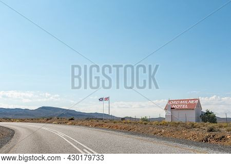 Matjiesfontein, South Africa - April 20, 2021: British Flags And A Building Next To The Entrance Roa