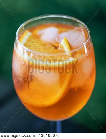 Aperol Spritz Aperitivo summer cocktail drink in original glass with oranges and mint twig on wooden table background. Food and drink photography