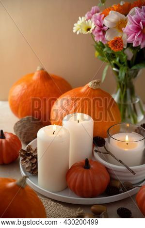 Autumn Centrepiece, Candles, Autumn Flowers And Pumpkins On Table