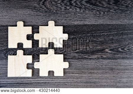 Three Puzzle Pieces In A Row On A Wooden Background Top View