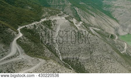 Top View Of Mountain Slopes With Dangerous Roads. Action. Winding Roads On Slopes Of Green Mountains