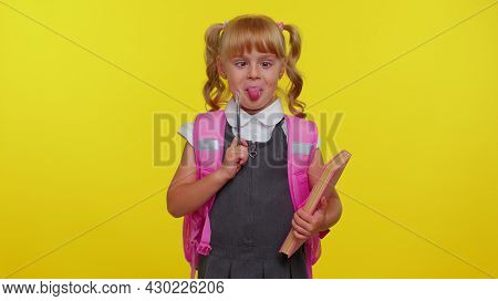 Joyful Funny Schoolgirl Wears Backpack, Making Humorous Face With Eyes Crossed, Playing Fool, Having