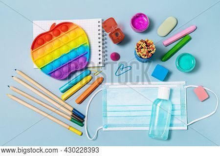 School Supplies, Poppit Anti-stress, Face Mask, Bottle Of Sanitizer, For Back To School On A Blue Ba